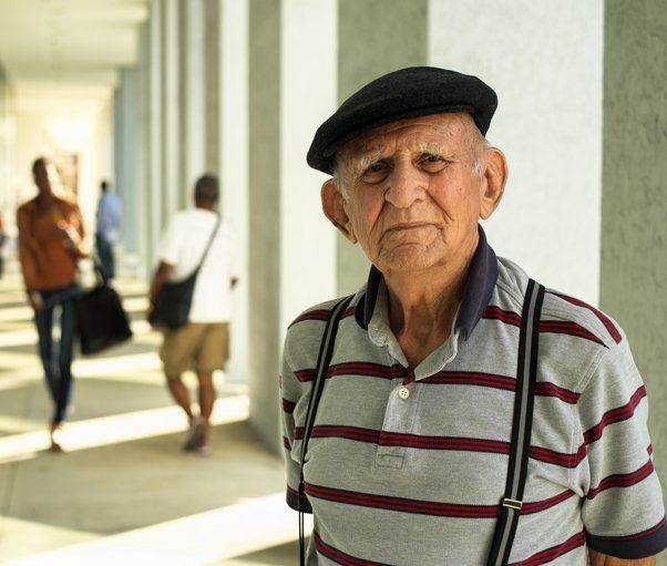 An elderly man standing in a corridor