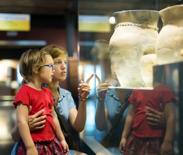 A lady pointing out a museum exhibit to a child