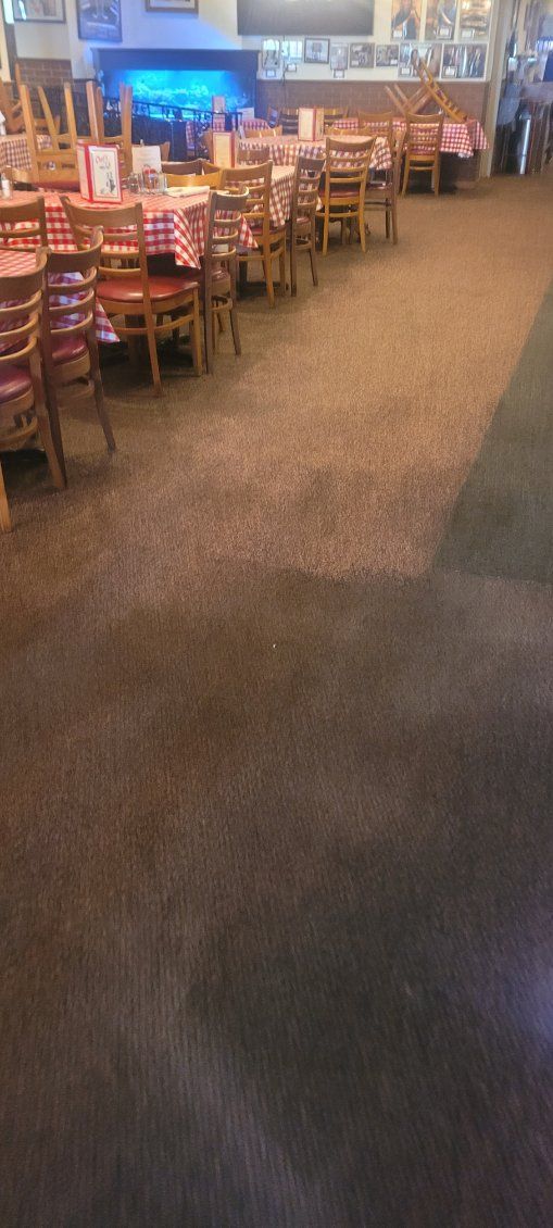 A restaurant with tables and chairs and a carpeted floor.