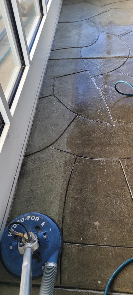 A vacuum cleaner is being used to clean a concrete floor.
