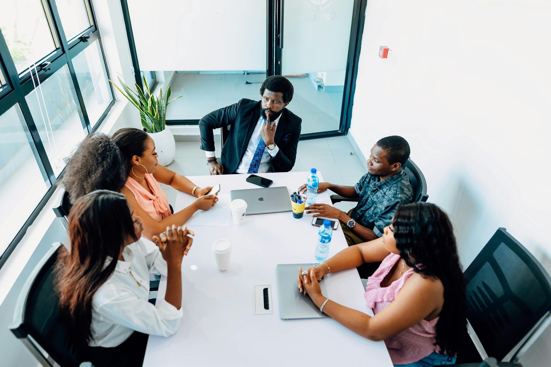 A group of people are sitting around a table having a meeting.