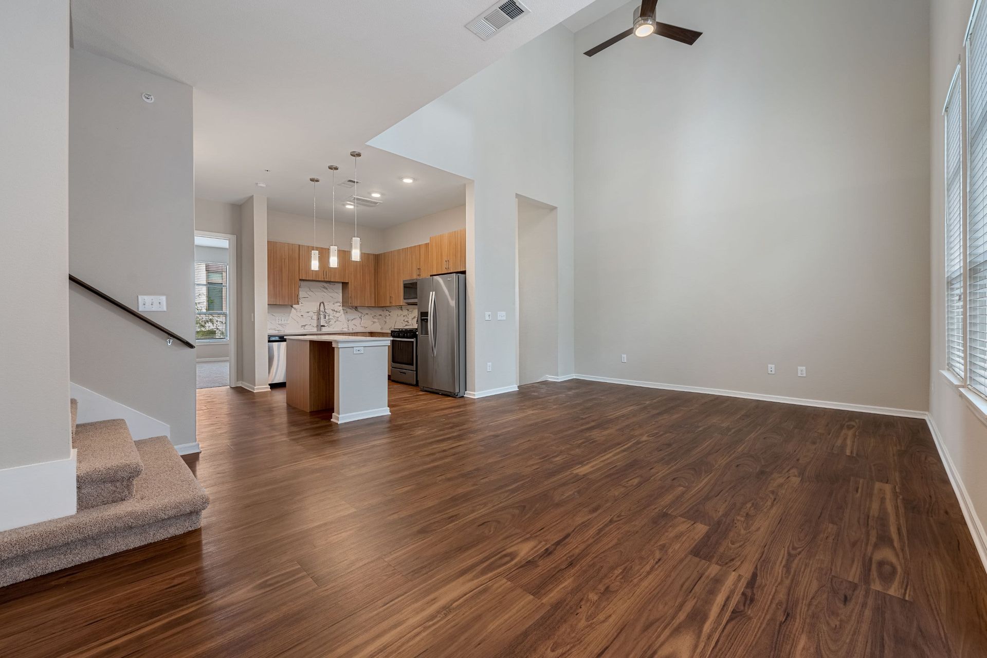 a living room with hardwood floors and a kitchen in the background at Westerly 360 in Austin, TX.