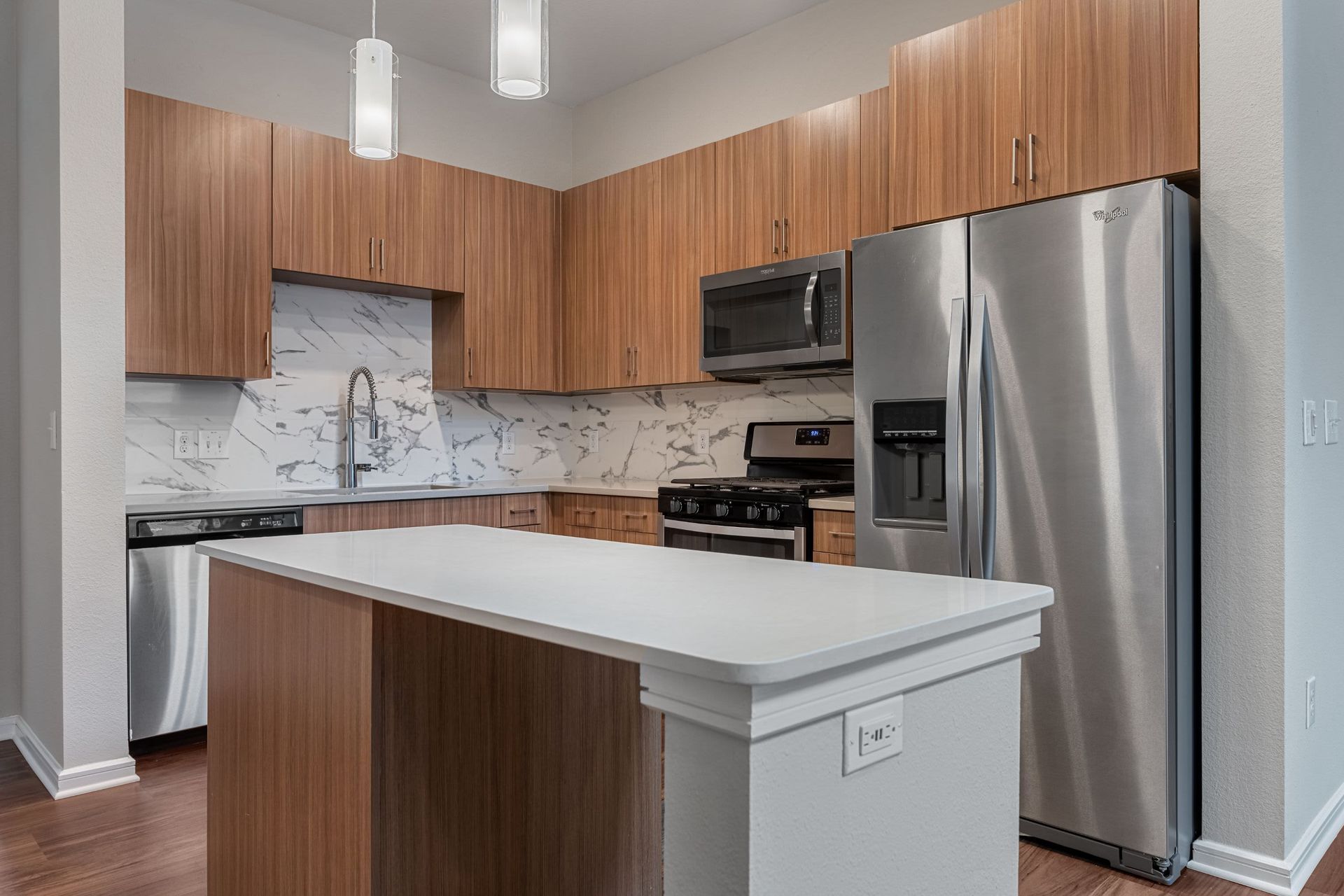 a kitchen with stainless steel appliances and wooden cabinets at Westerly 360 in Austin, TX.