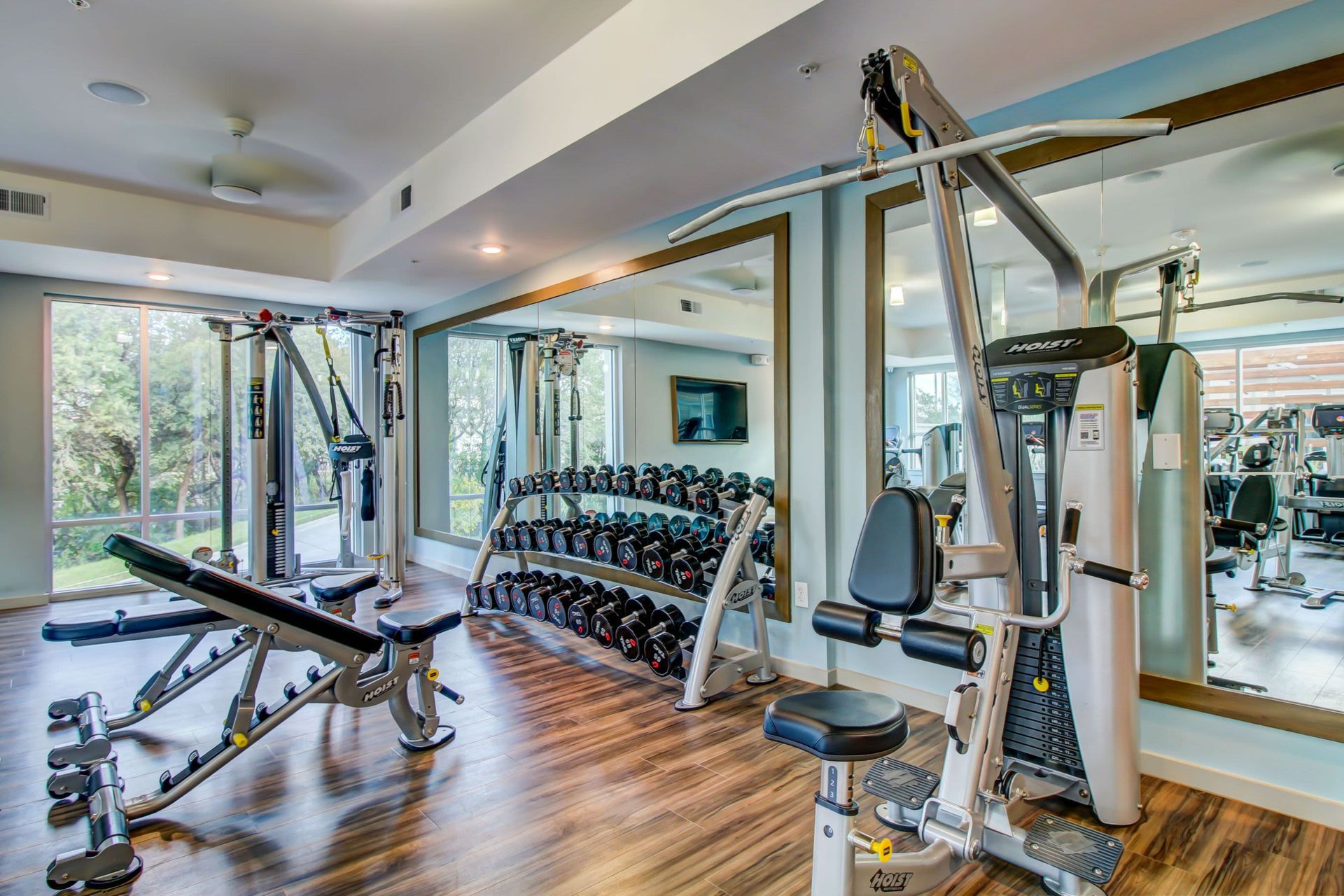 a gym with a lot of equipment and a lot of mirrors at Westerly 360 in Austin, TX.