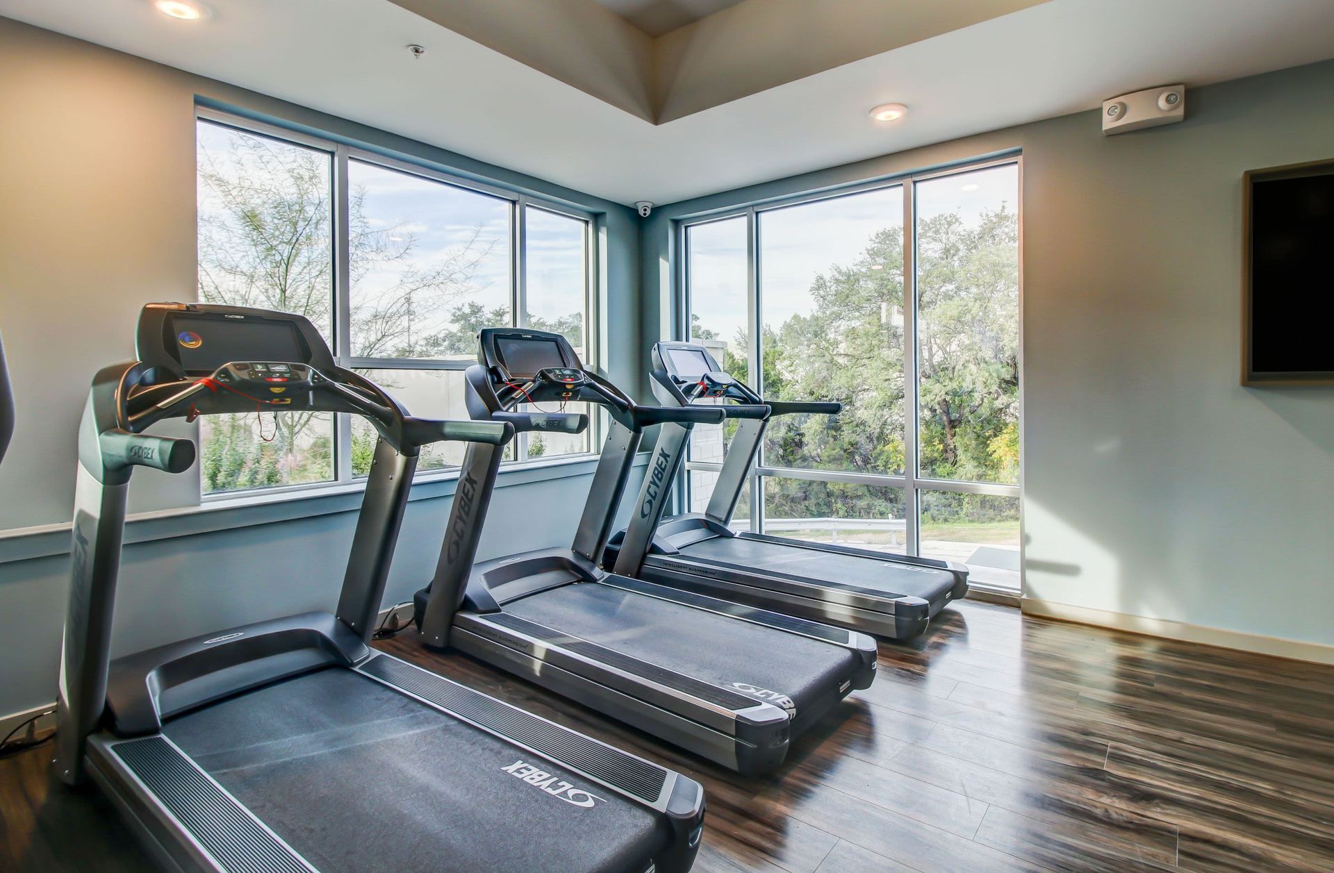 a gym with treadmills and a television on the wall at Westerly 360 in Austin, TX.