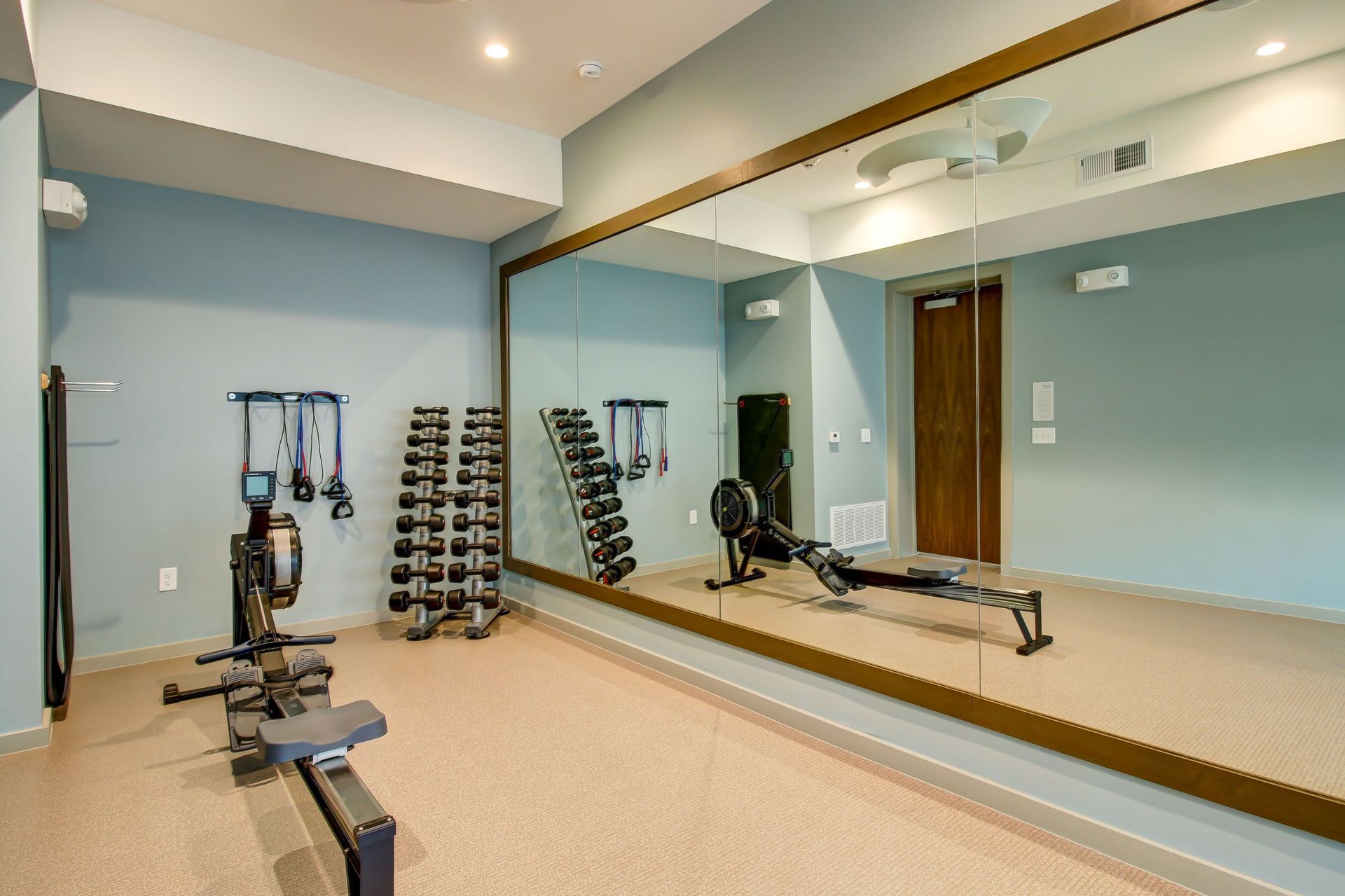 a gym with a lot of mirrors and exercise equipment at Westerly 360 in Austin, TX.