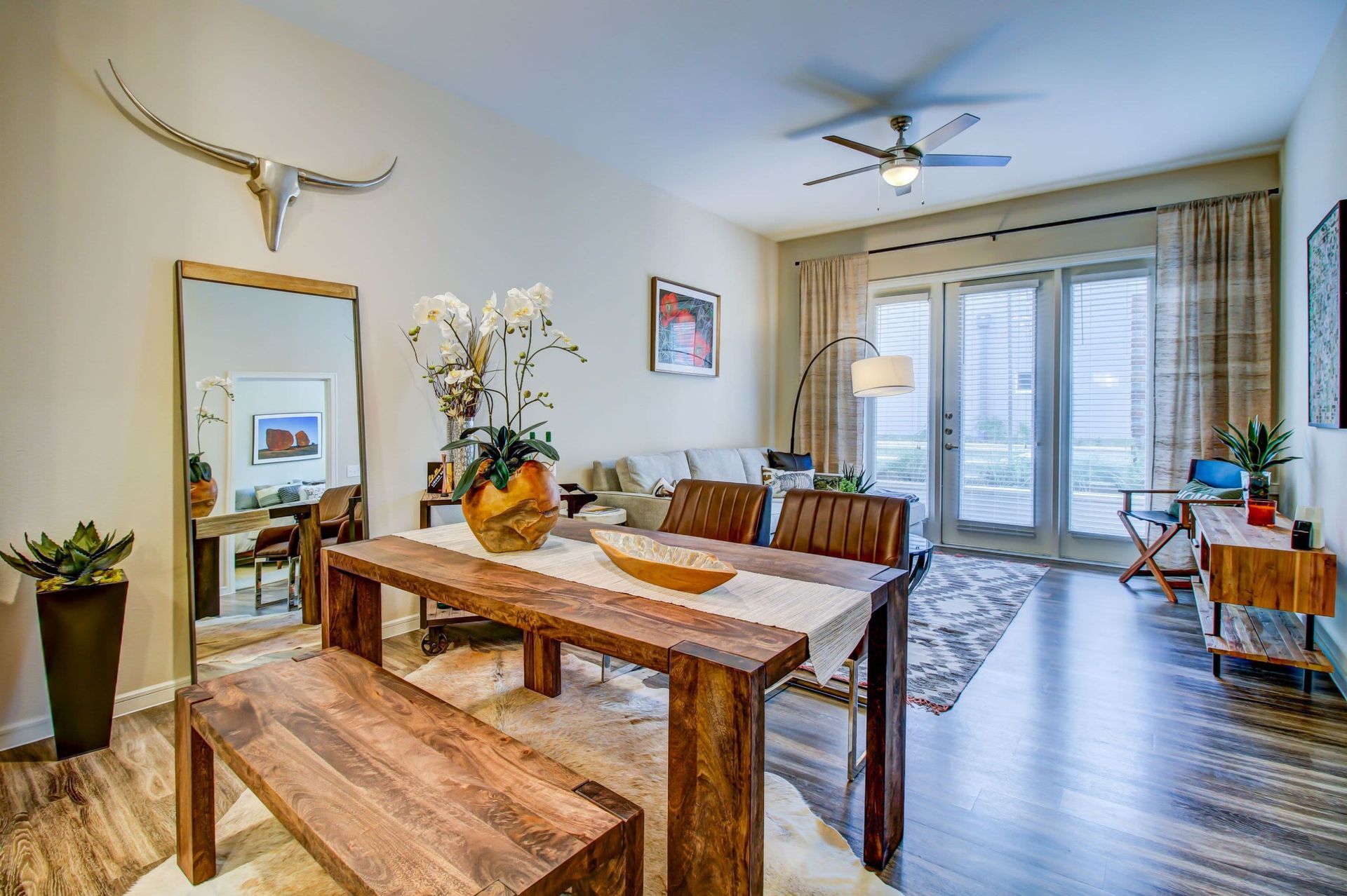 a living room with a wooden table and chairs and a ceiling fan at Westerly 360 in Austin, TX.