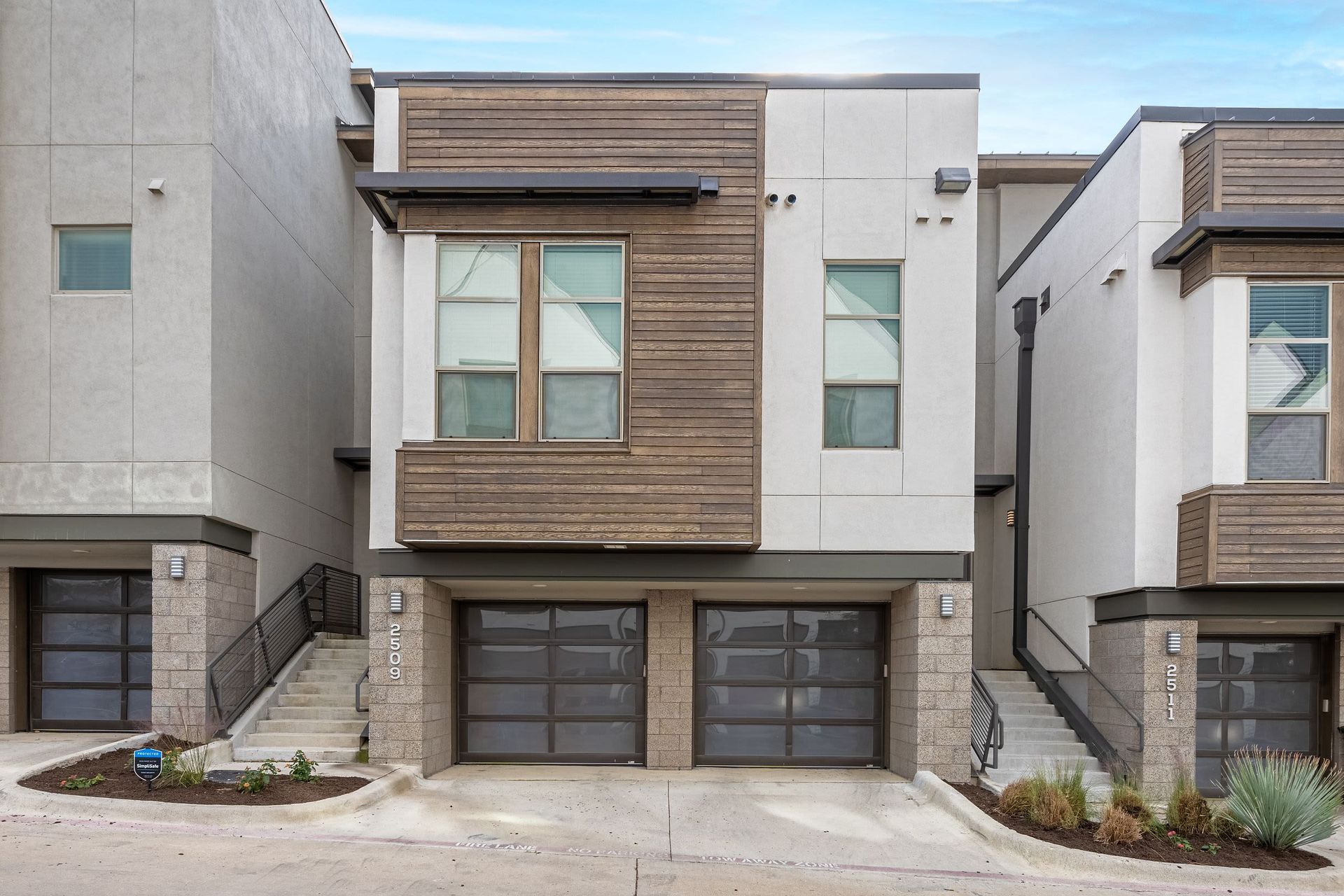 a modern house with two garages and stairs leading up to it at Westerly 360 in Austin, TX.
