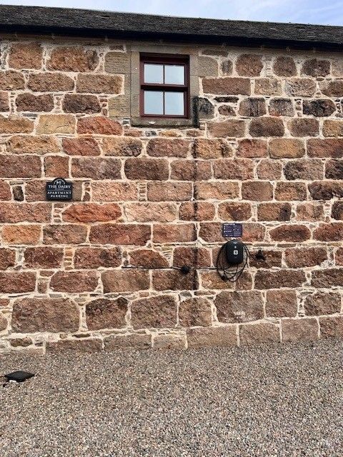 A brick wall with a window on the side of it.