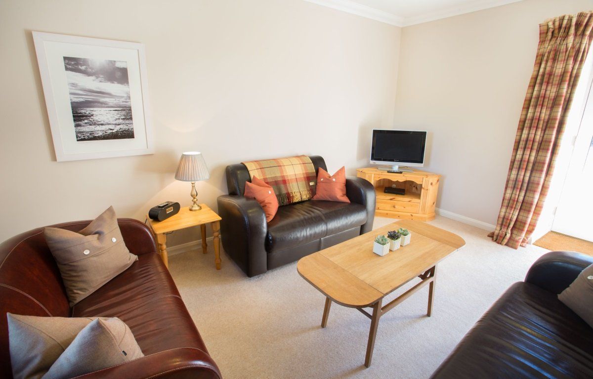 A living room with a couch , table , and television.