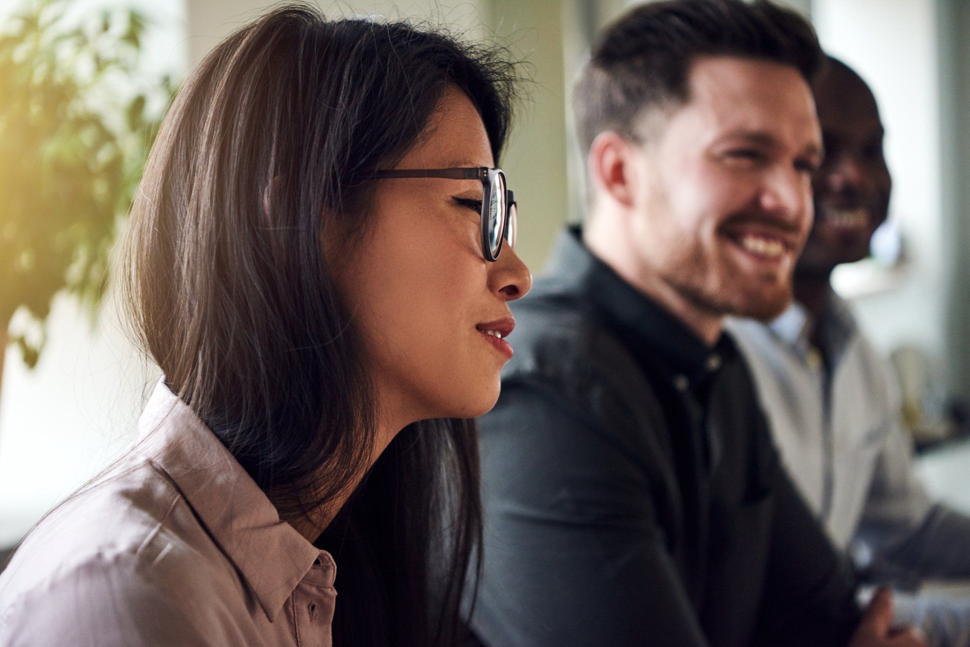 A group of people are sitting in a row and talking to each other.