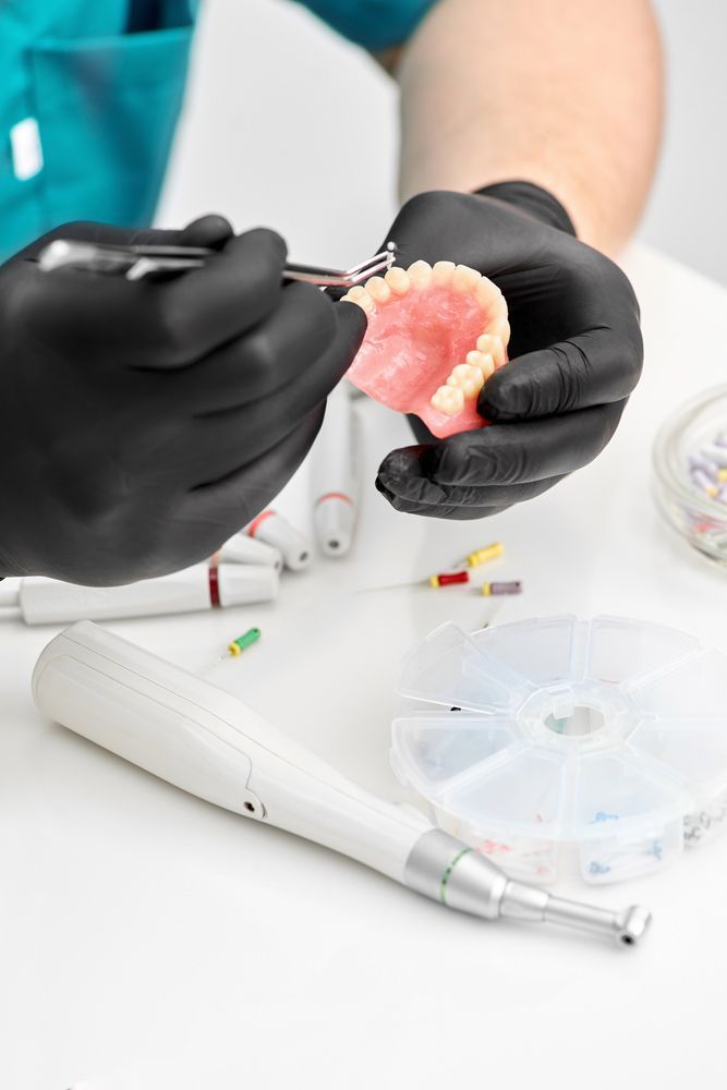 Prosthetics Hands While Working On The Denture —  Smiles on Hobart In Hobart TAS
