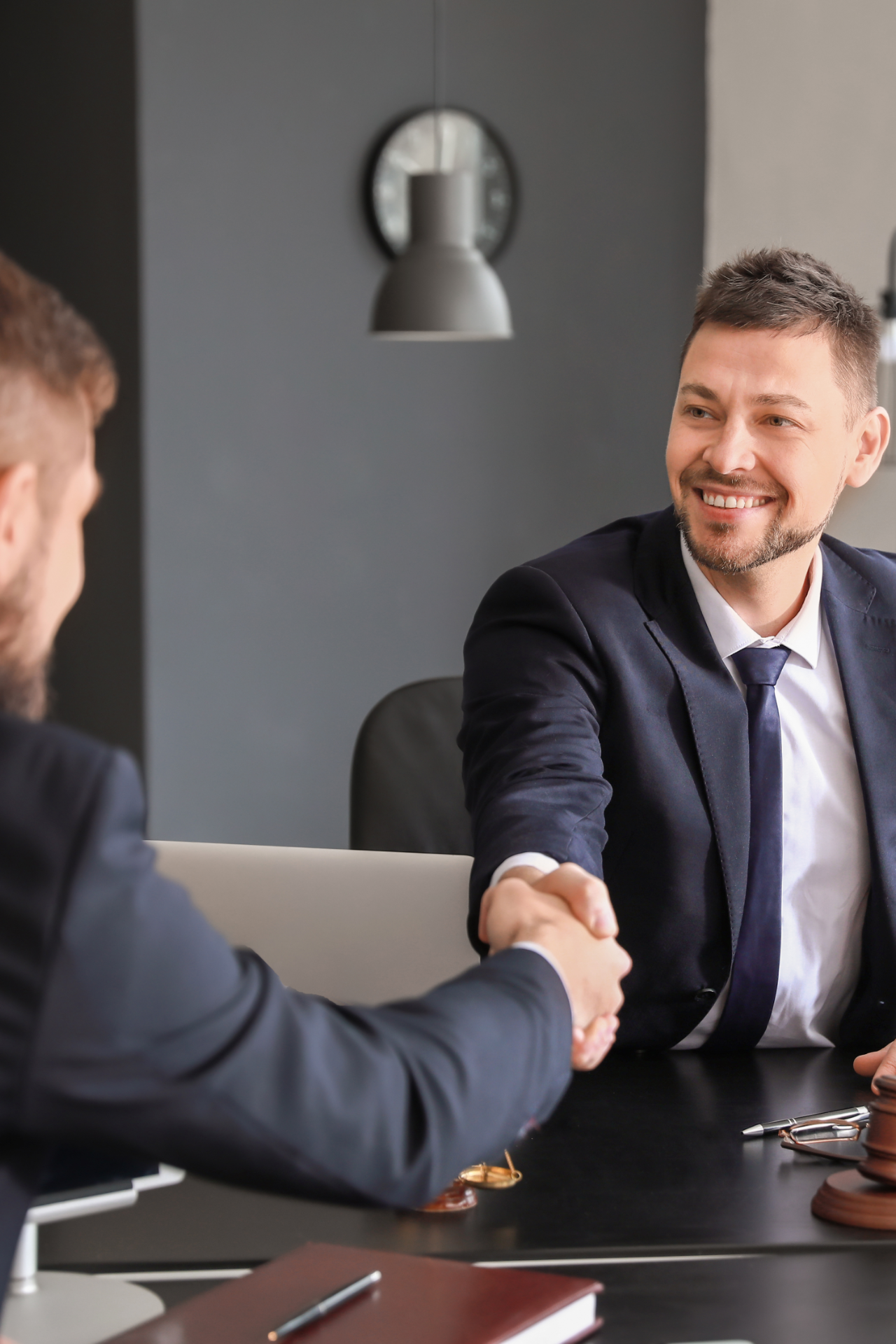 male lawyer with client shaking hands in office