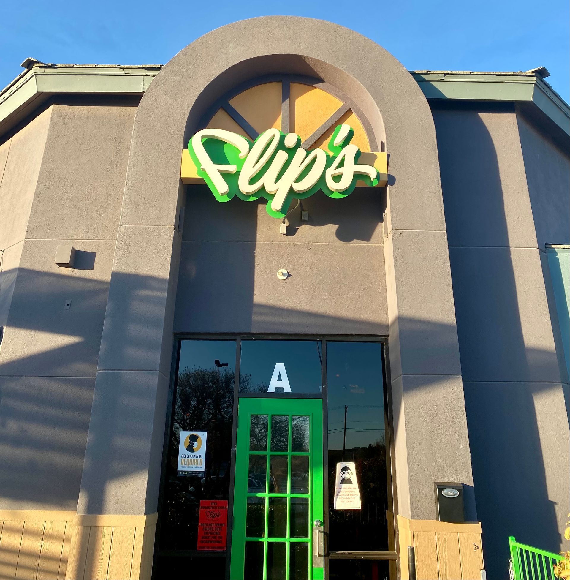 The front of a flip 's restaurant with a green door
