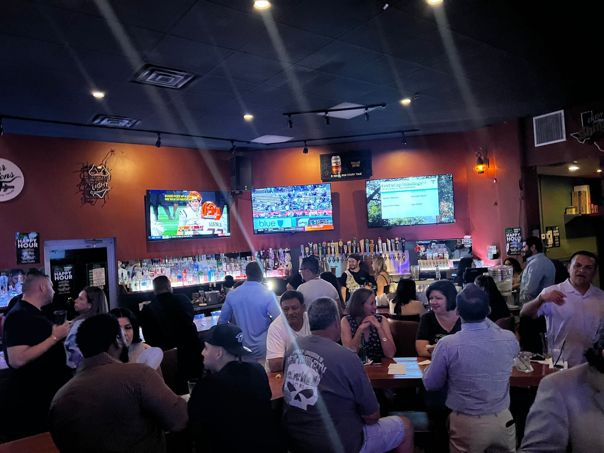 A group of people are sitting at tables in a bar