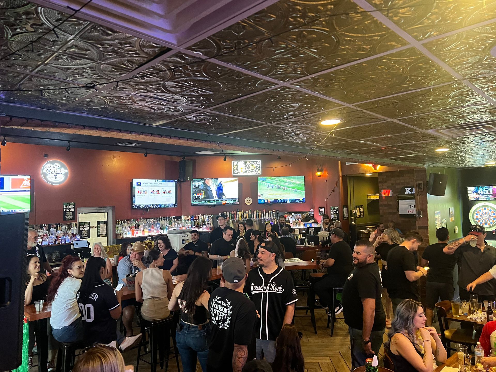 A large group of people are sitting at tables in a bar.