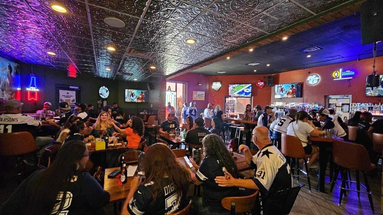 A large group of people are sitting at tables in a restaurant.