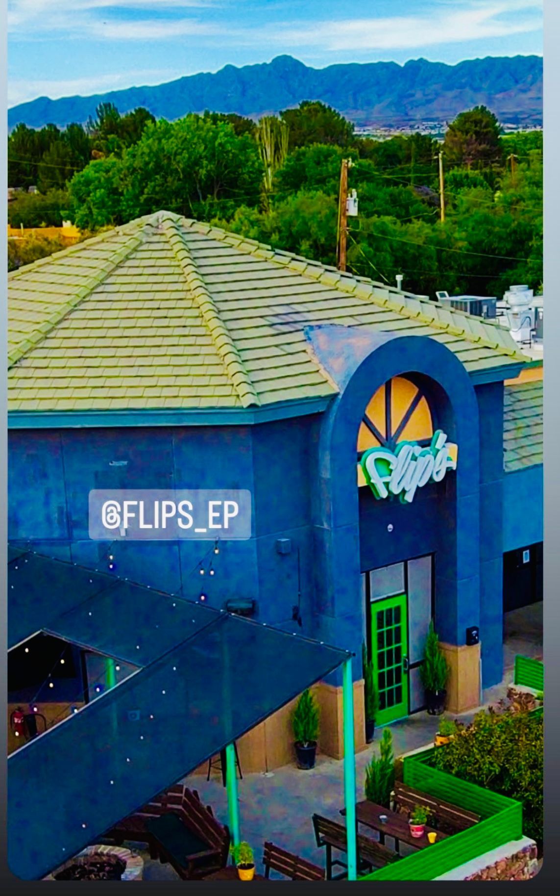 An aerial view of a blue building with a green door