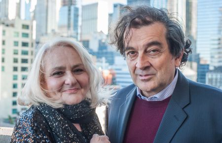 A city skyline at night with a very tall building in the foreground