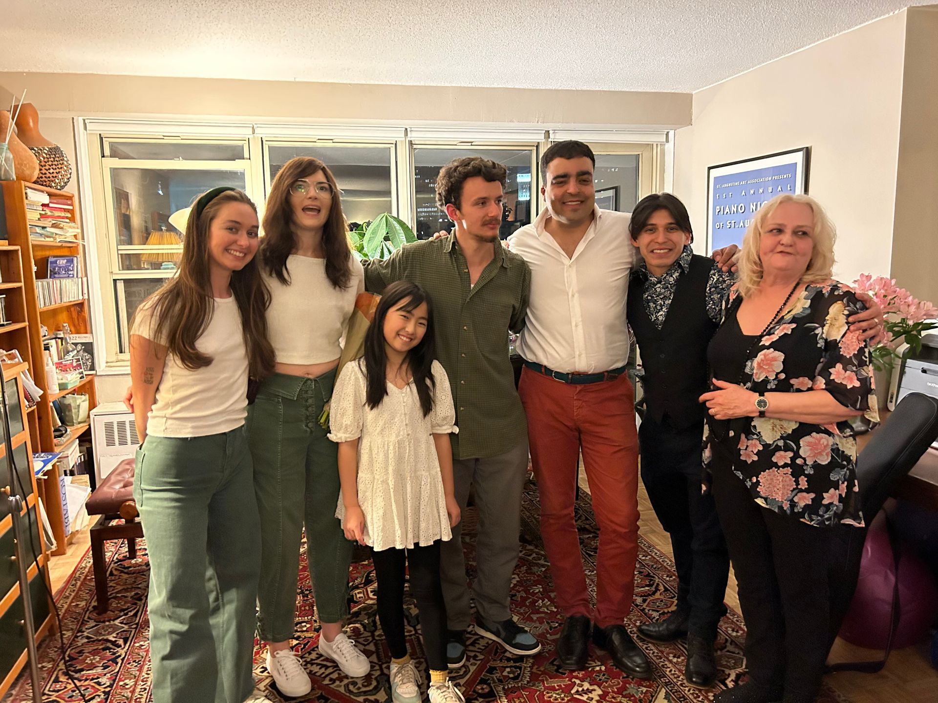 A group of people are posing for a picture in a living room.