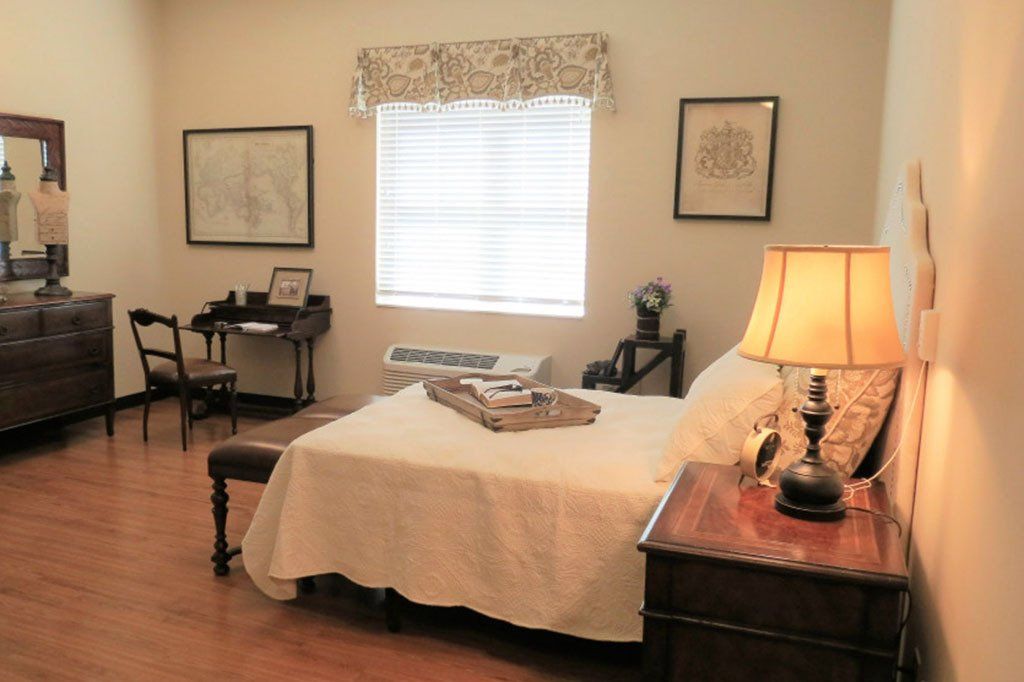 A bedroom with a large bed and a desk
