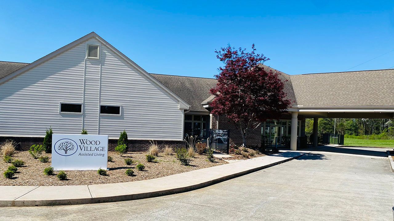 A large white building with a sign in front of it.