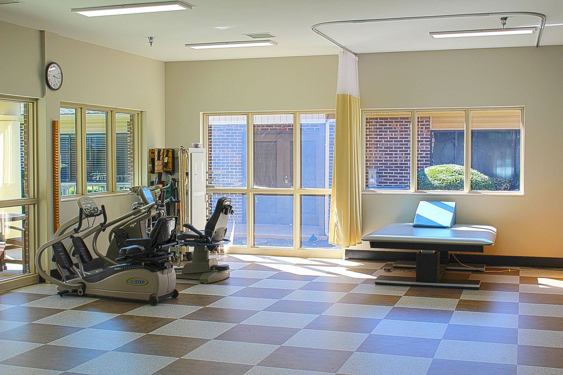 A gym with a checkered floor and a clock on the wall