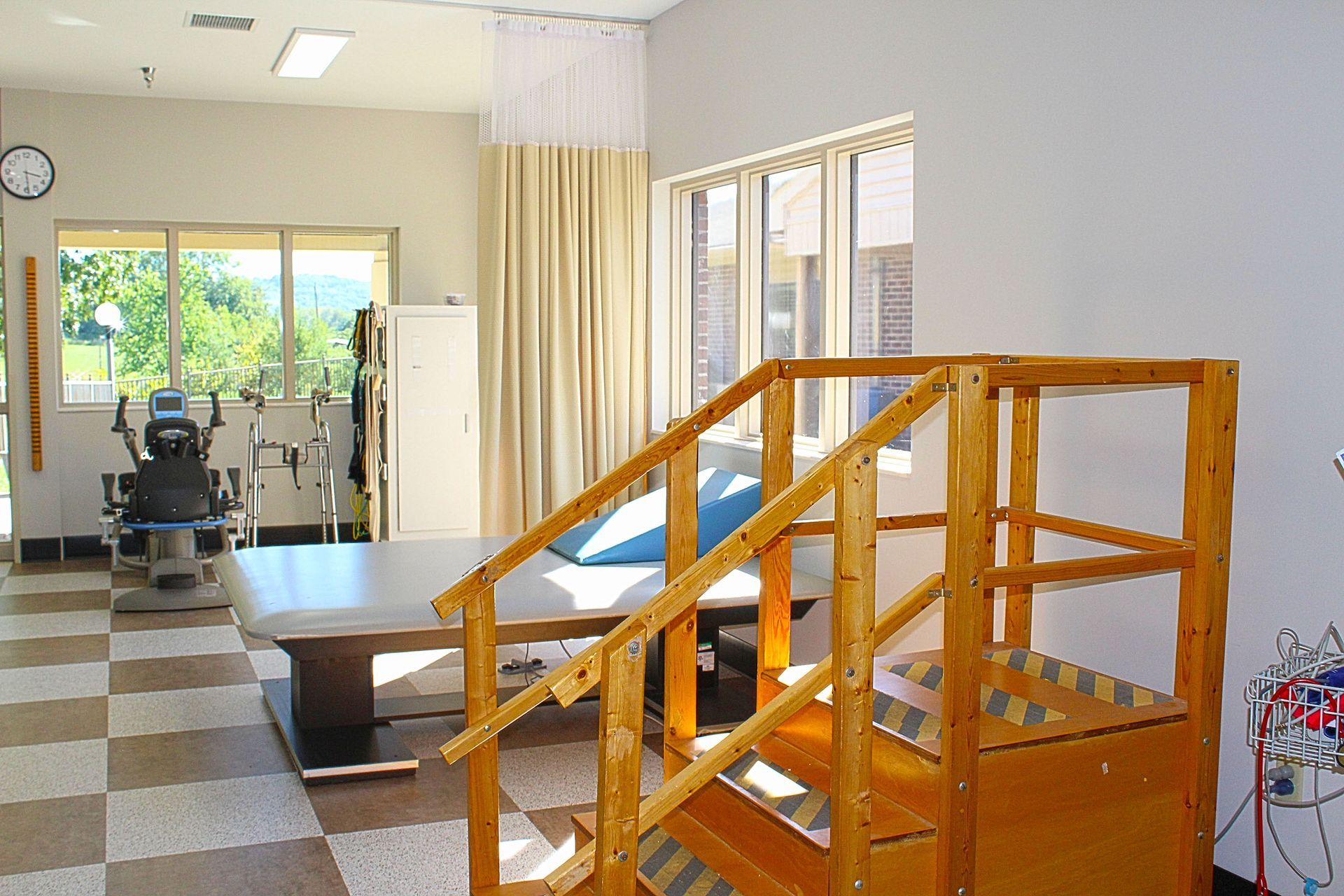 A room with a table and stairs and a clock on the wall