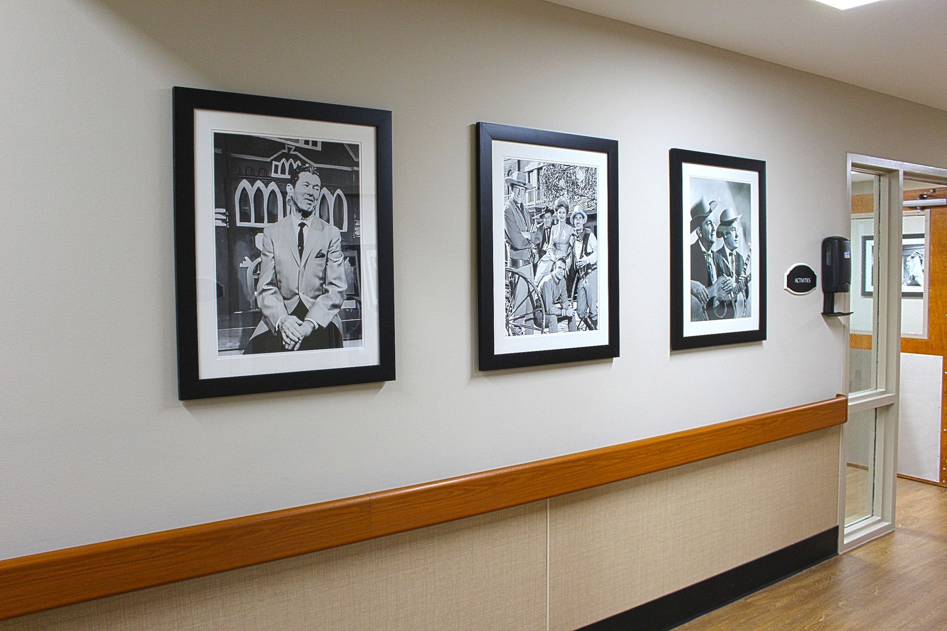 Three framed pictures hang on a wall in a hallway