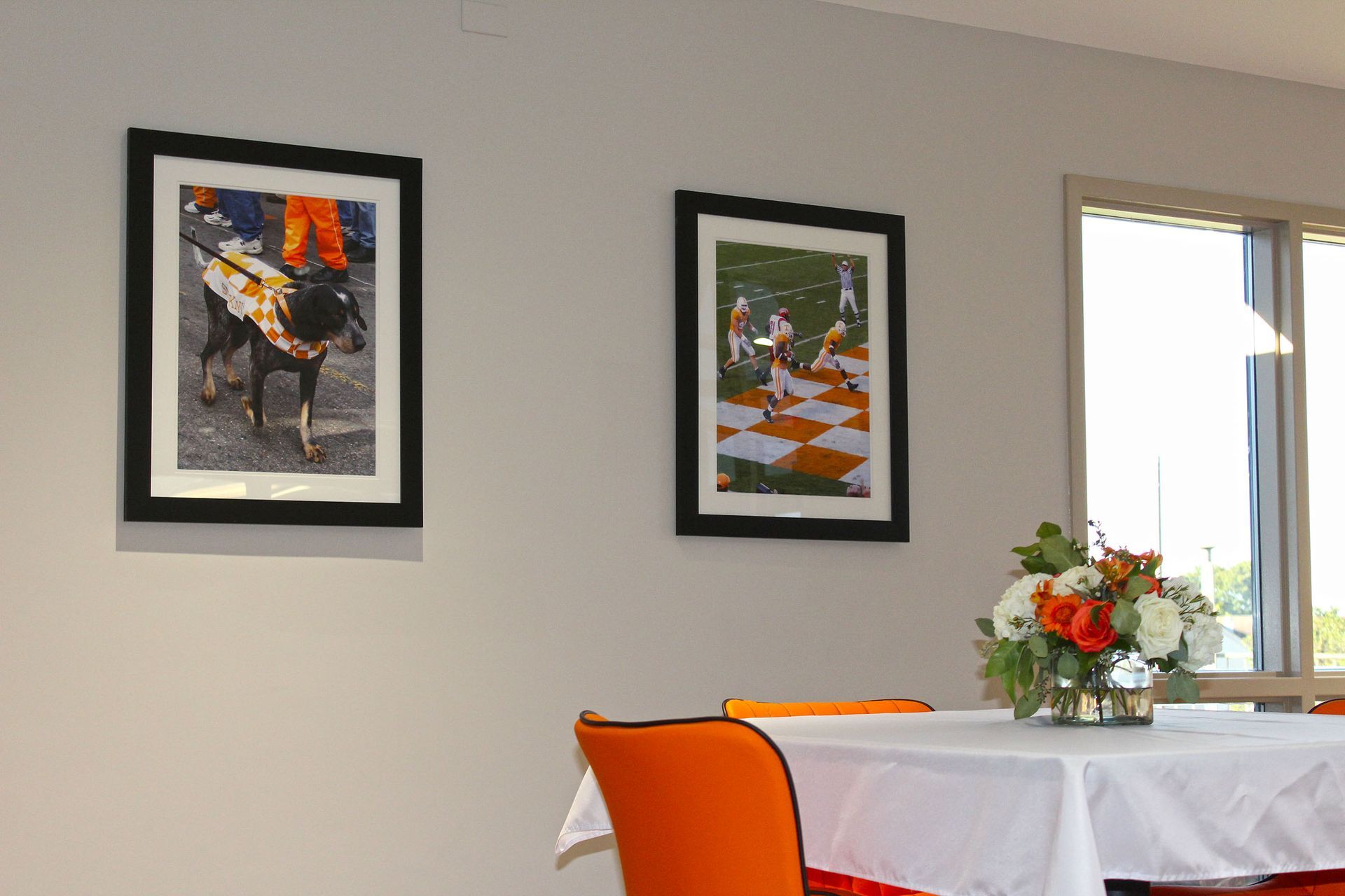 Two framed pictures hang on a wall above a table