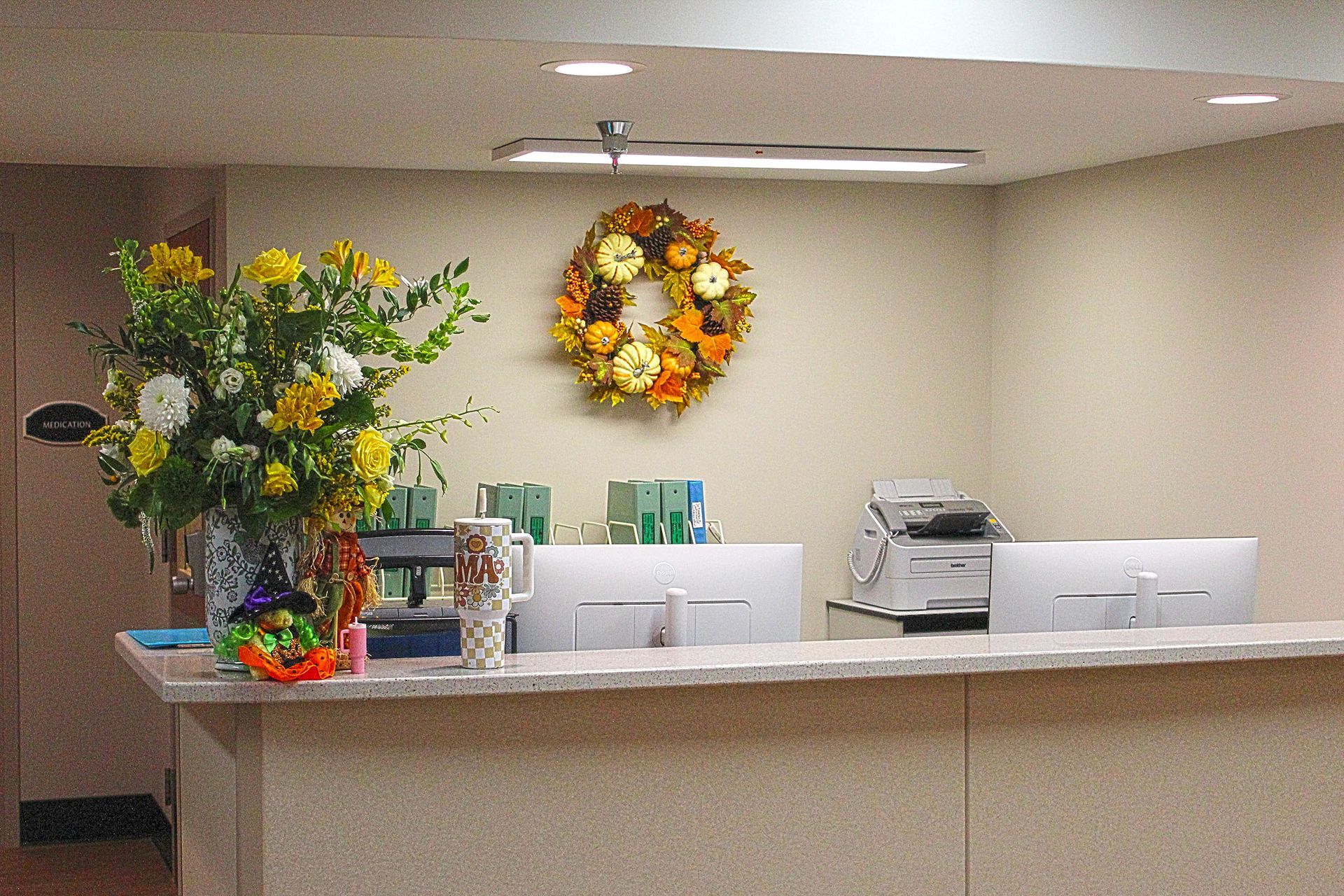 A reception desk with a wreath on the wall above it
