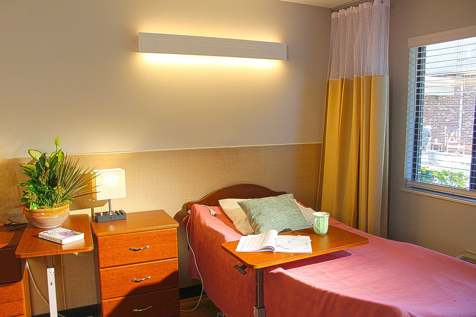 A hospital room with two beds and a window