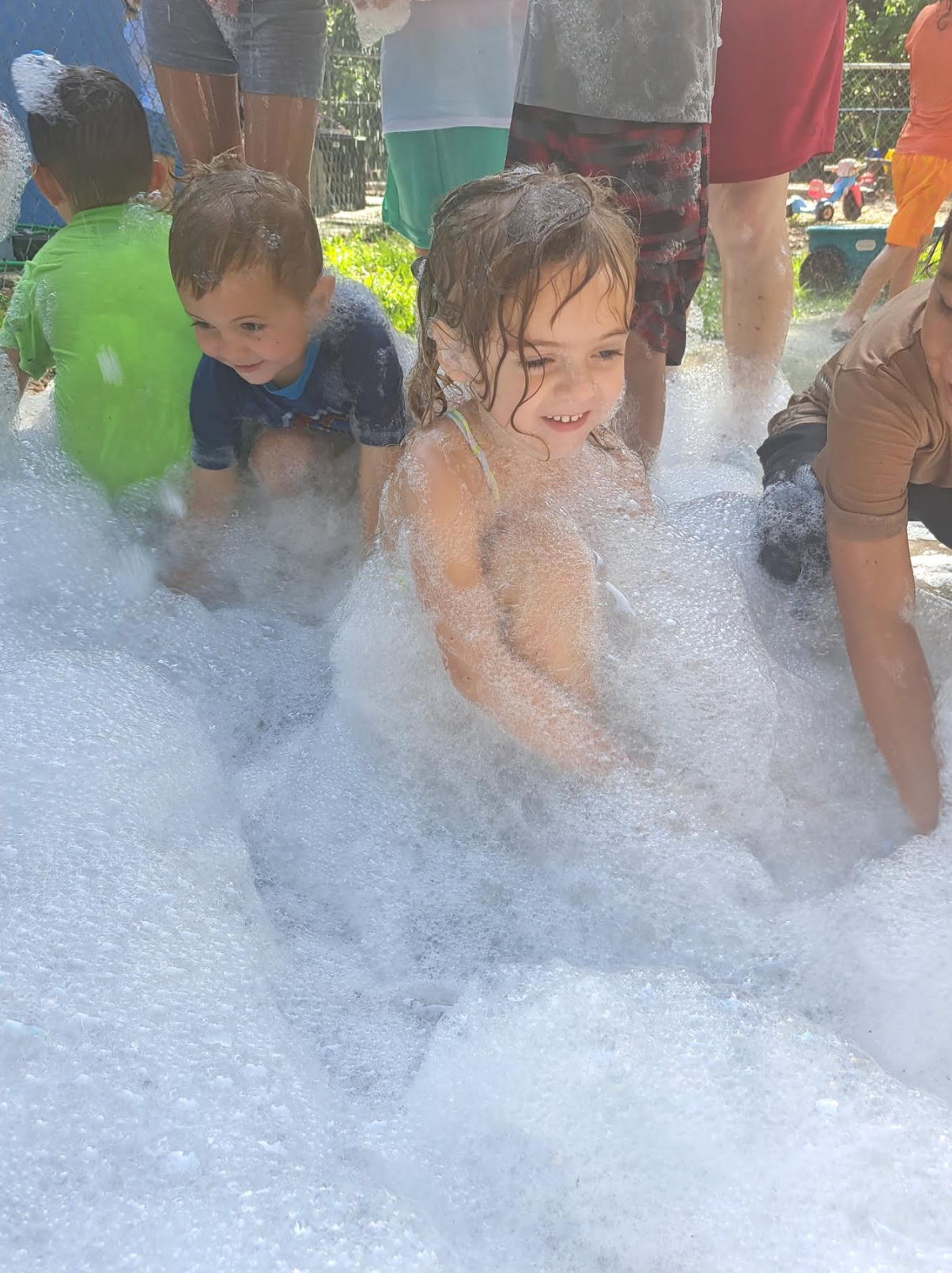 A group of children are playing in a pool of foam.