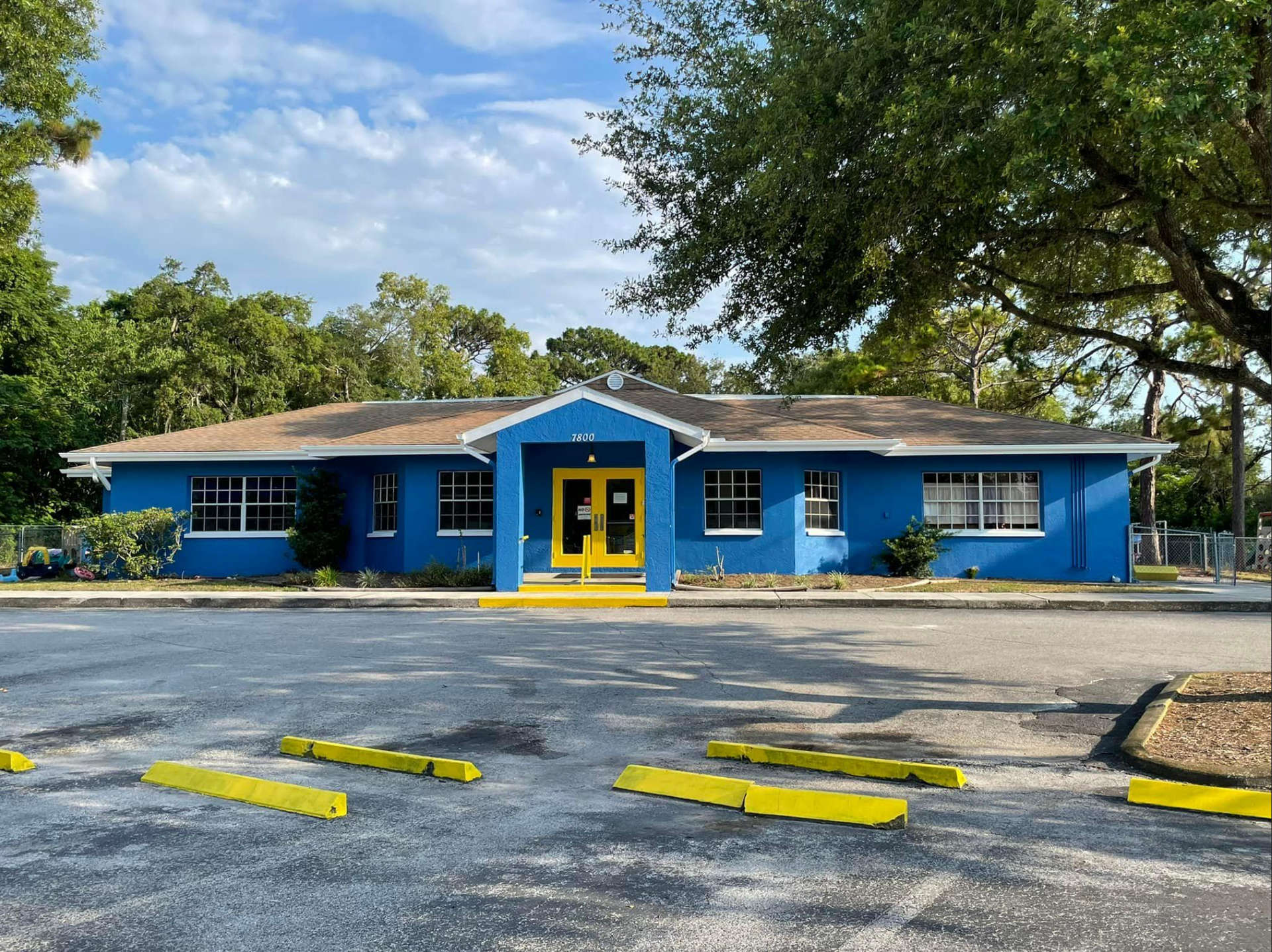 A blue building with a yellow door and the letter f on it