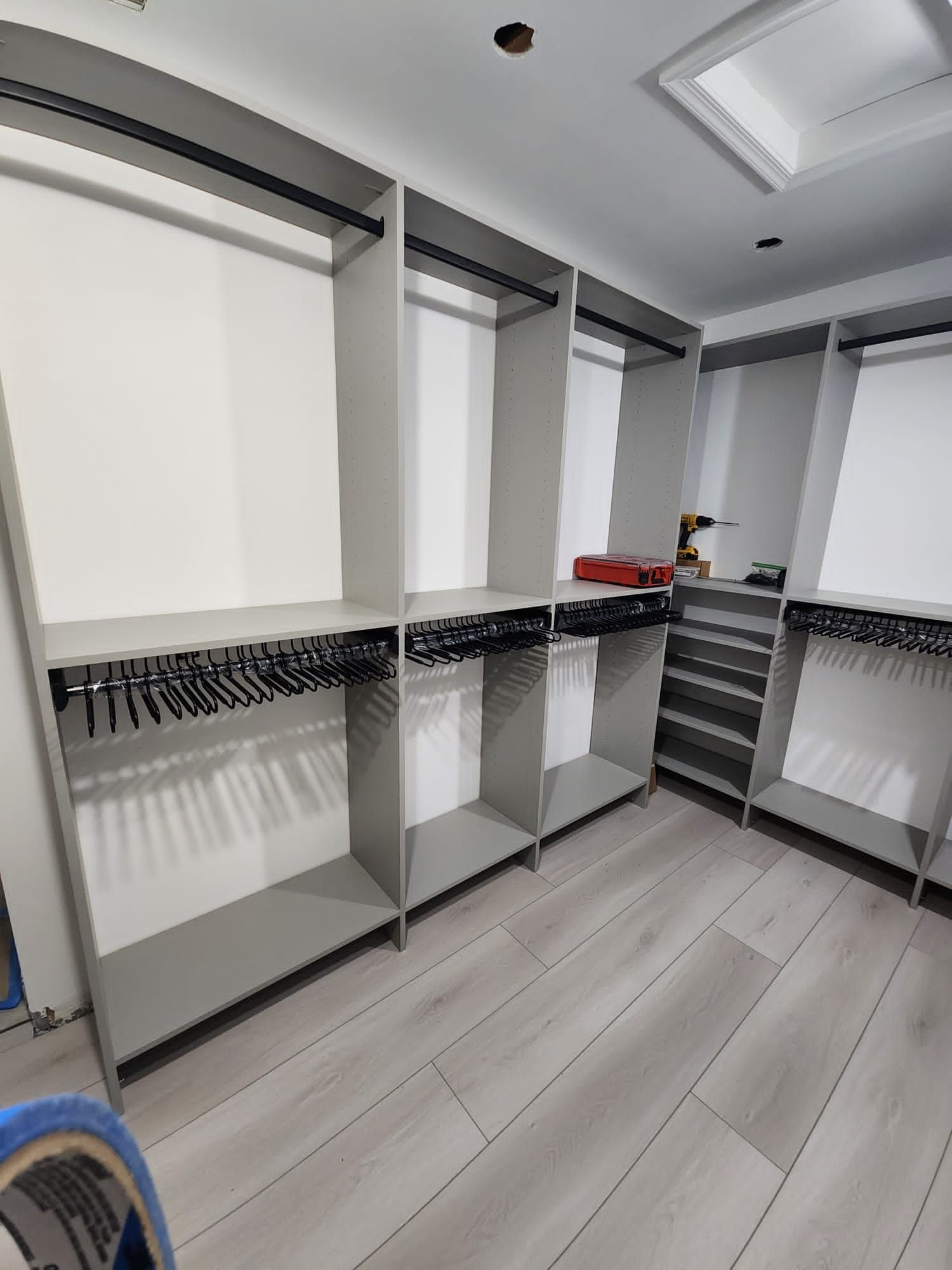 A walk in closet with lots of shelves and clothes racks