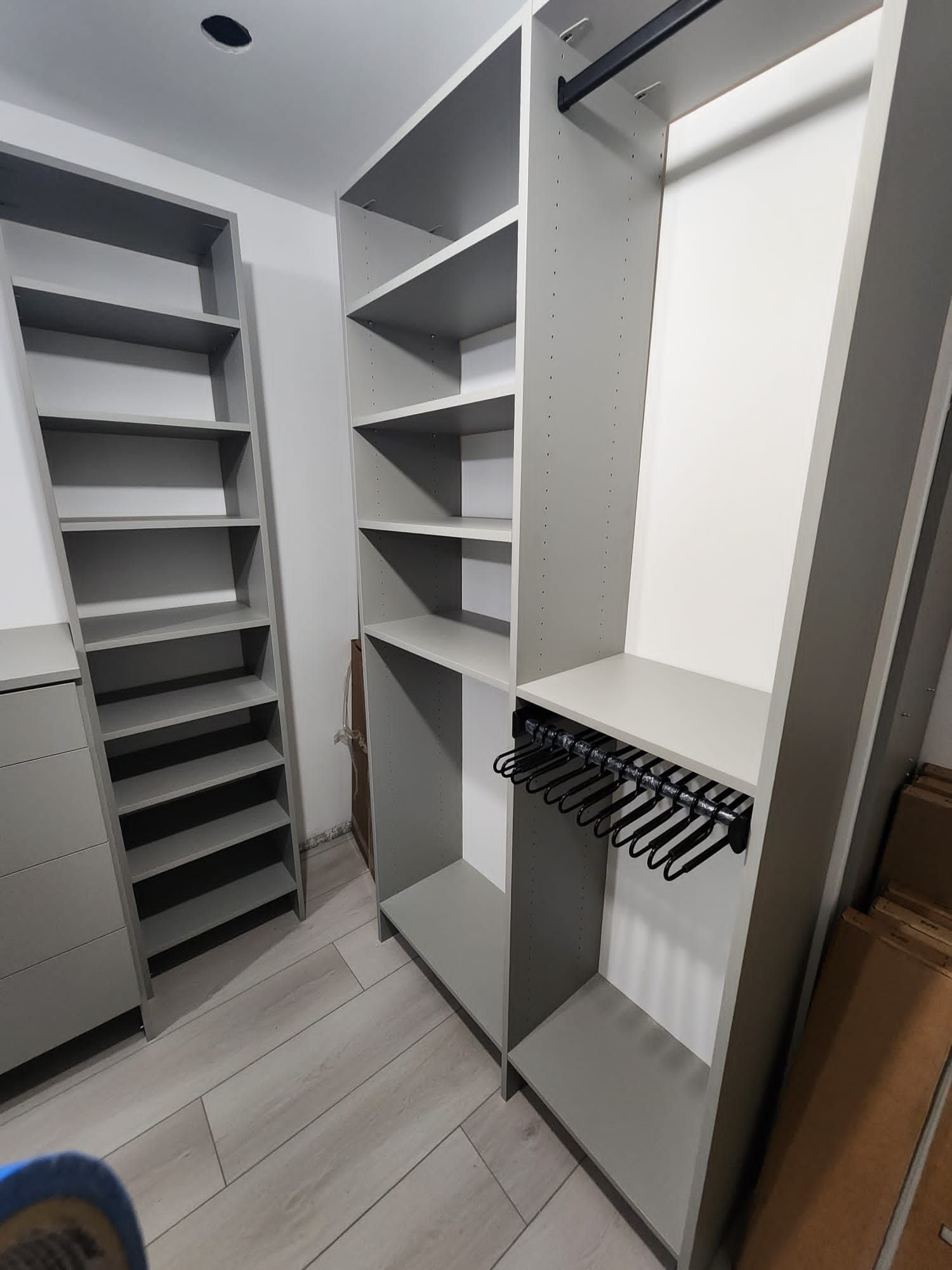 A walk in closet with lots of shelves and a tie rack