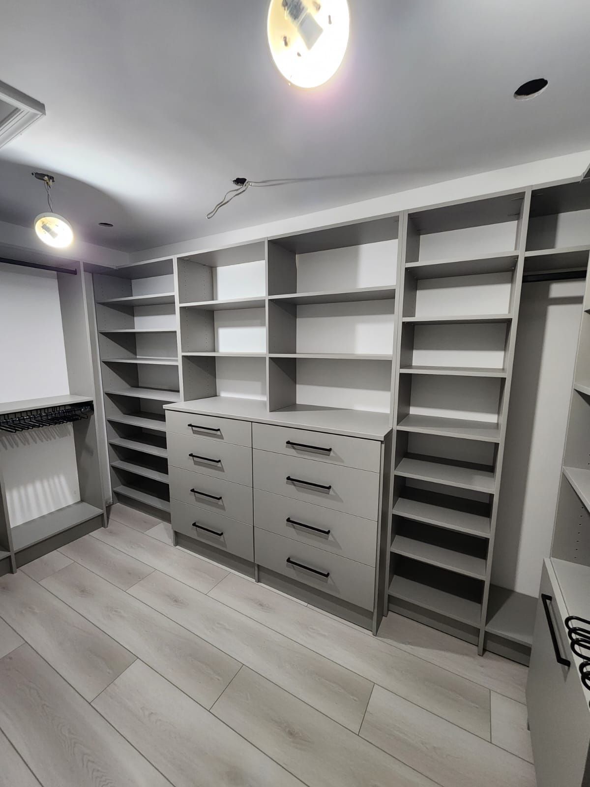 A walk in closet with lots of shelves and drawers.