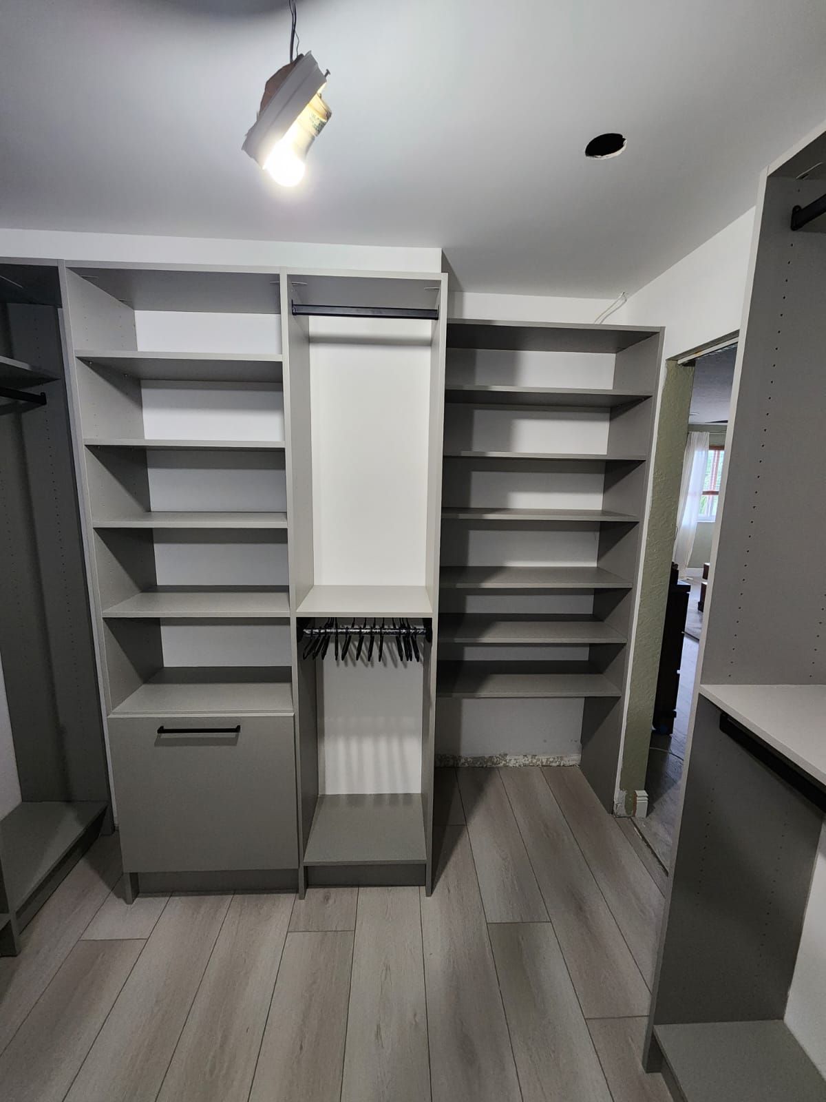 A walk-in closet room with a lot of shelves and a door
