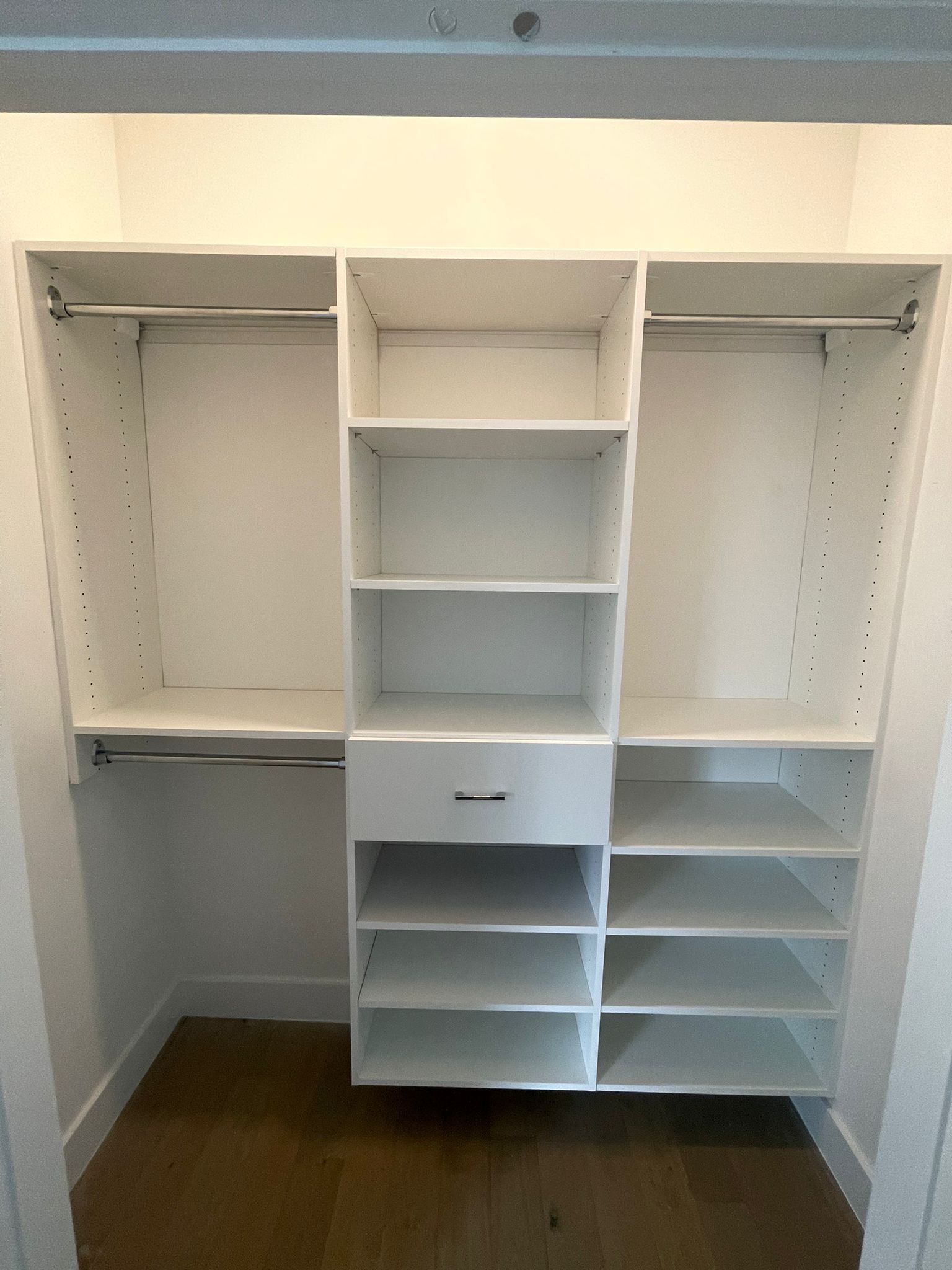 A reach-in closet with lots of shelves and a mirror.