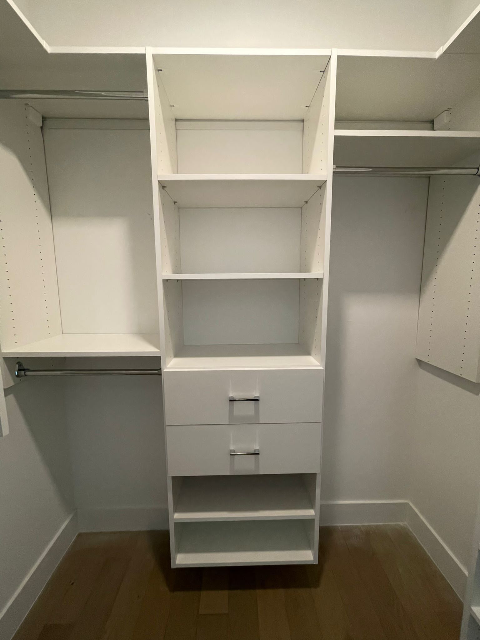 A reach-in closet with lots of shelves and drawers.