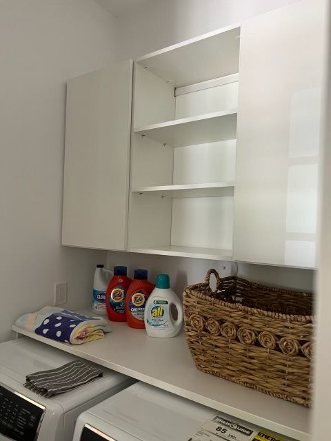 A laundry room with a washer and dryer and a basket