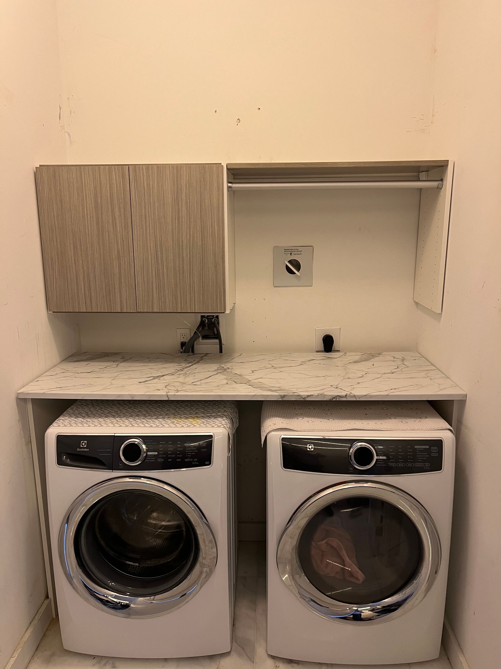 There are two washers and dryers in the laundry room.