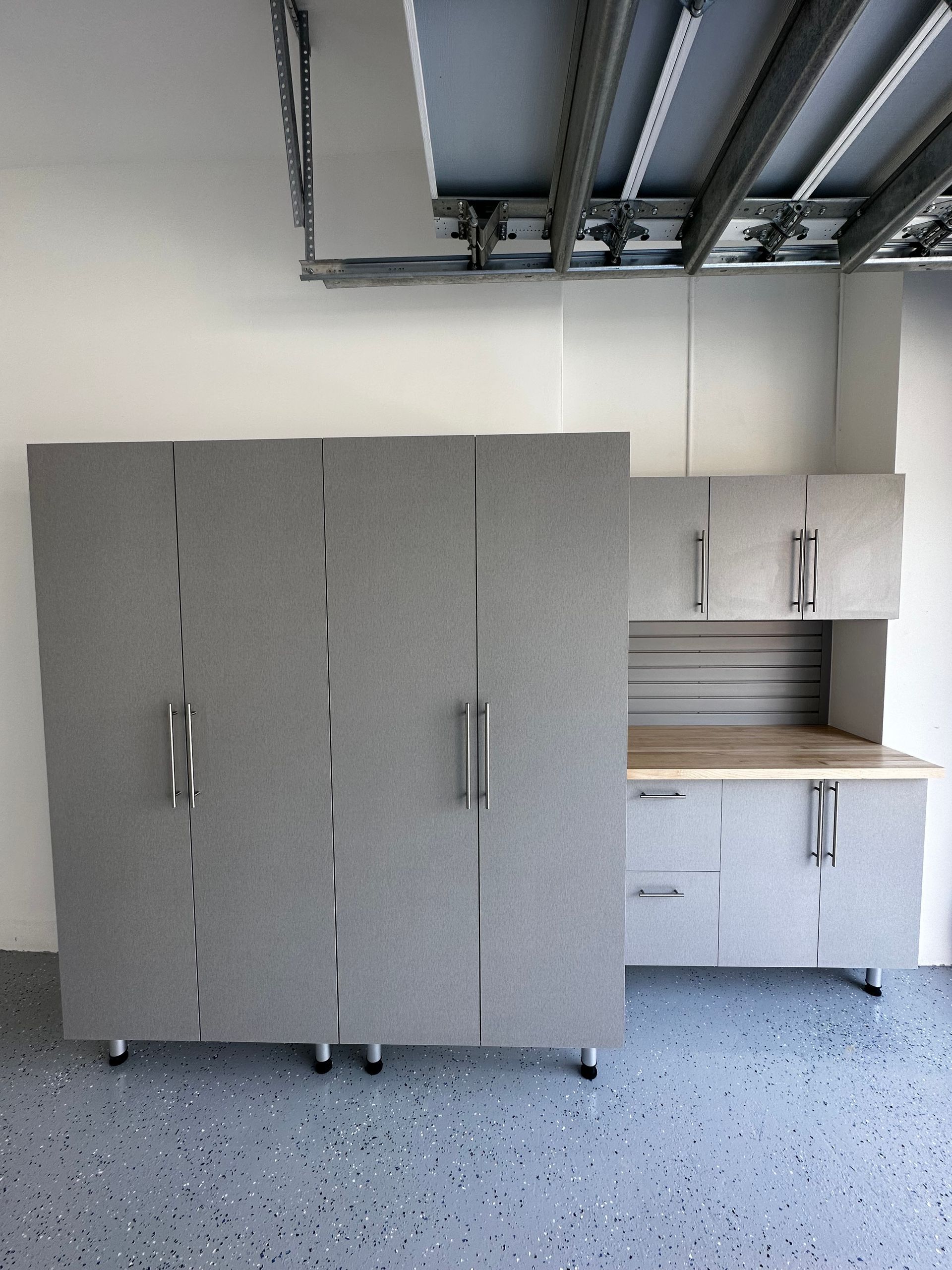 A garage with a lot of cabinets and a workbench