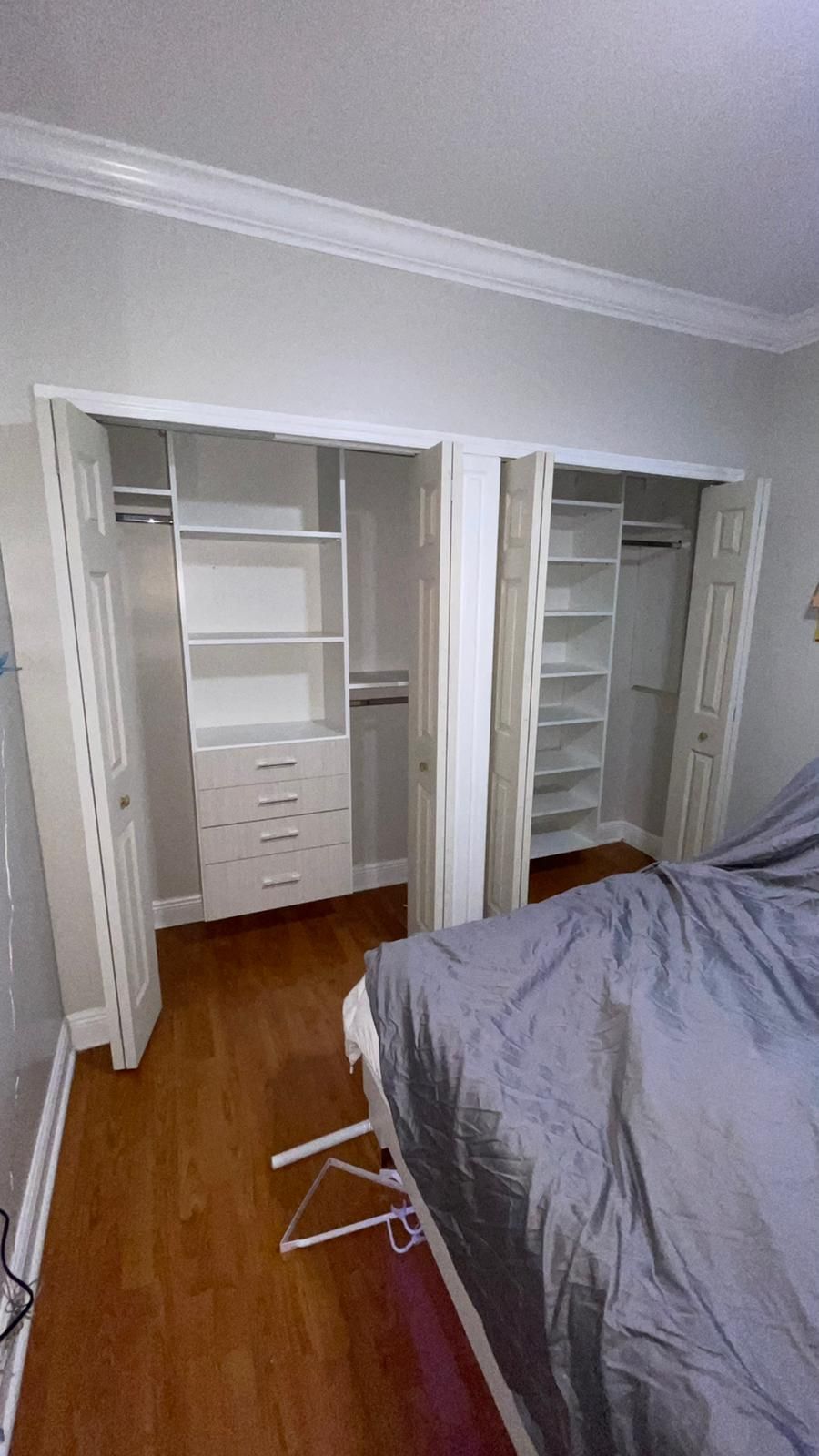A bedroom with a bed and a reach in closet.
