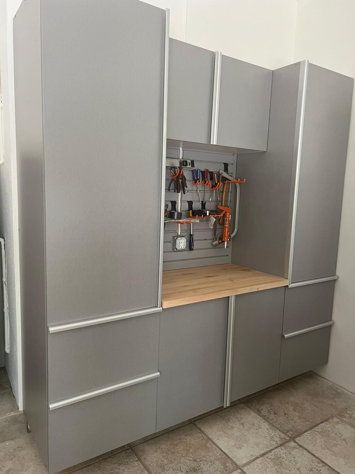 a custom grey garage cabinet and workbench