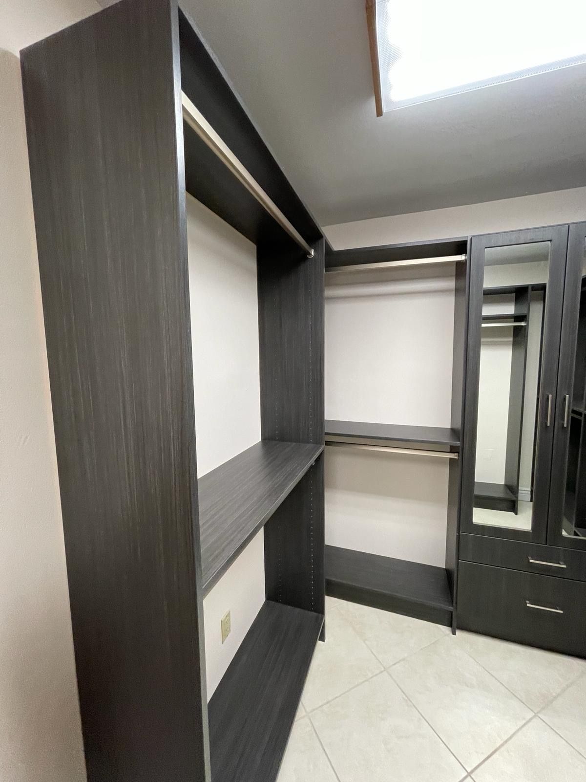 A walk in closet with lots of shelves