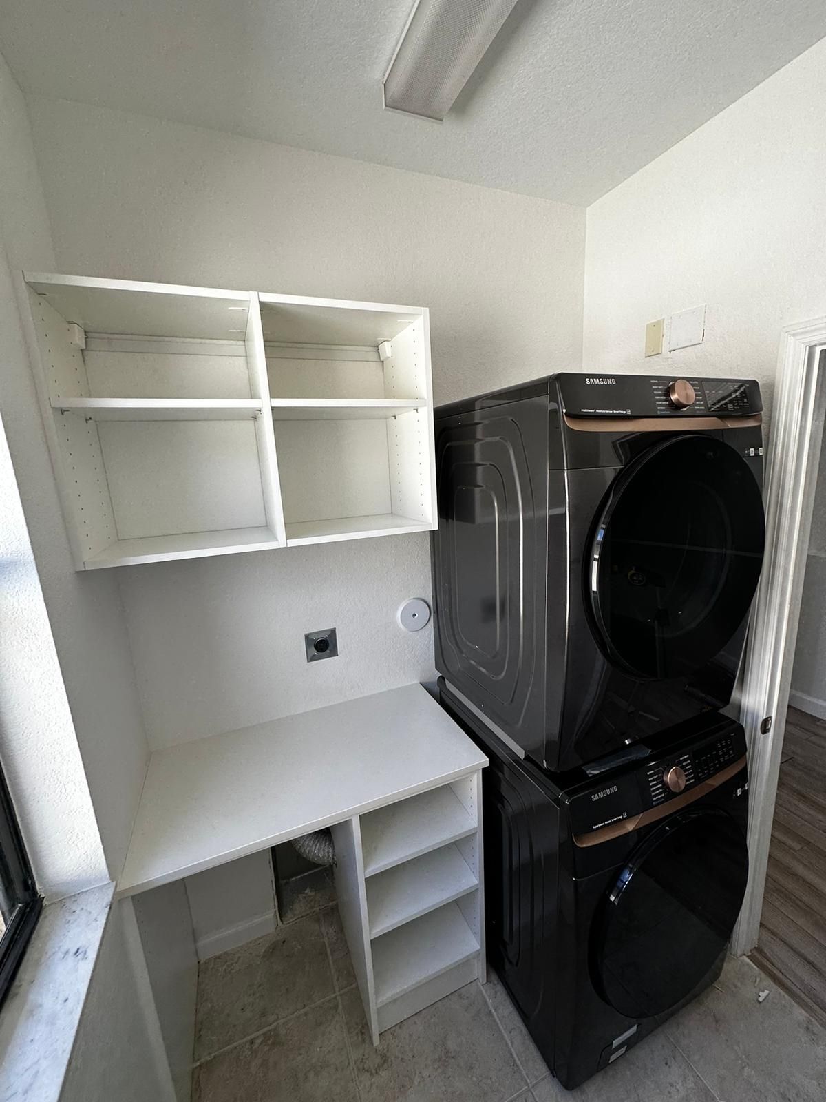 A laundry room with a washer and dryer stacked on top of each other.