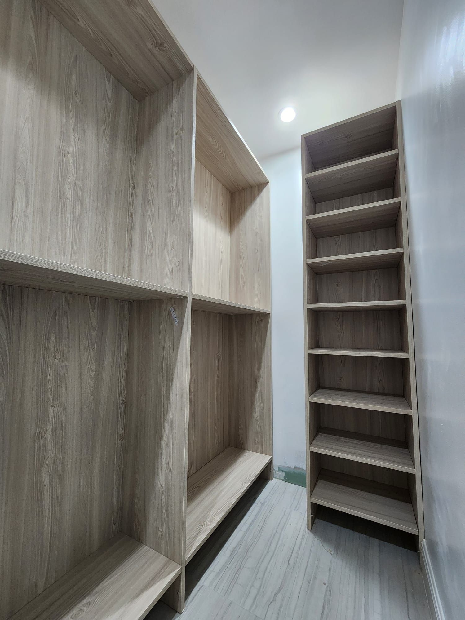 A wooden shelf with empty shelves in a room.