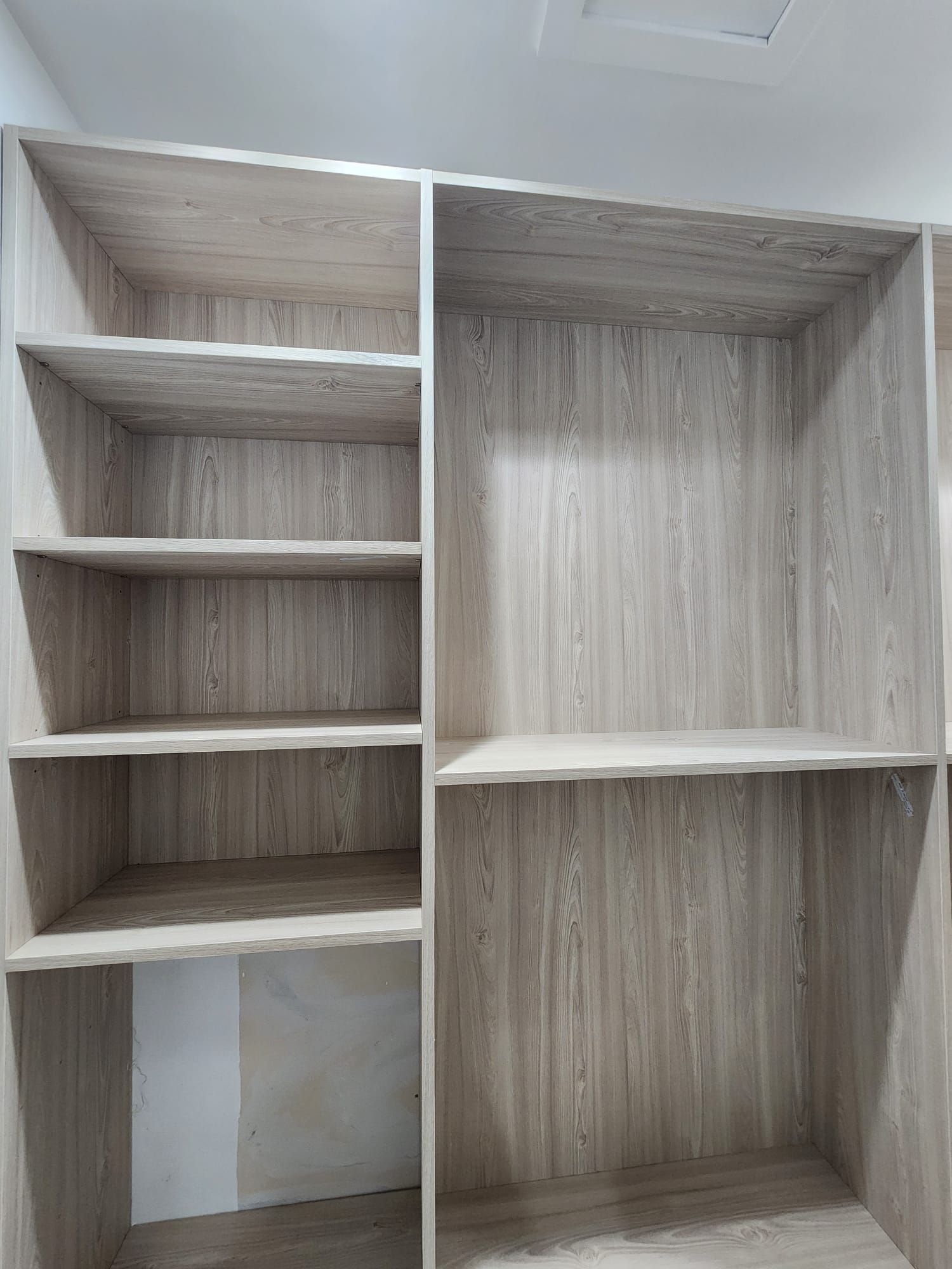 A walk in closet with lots of shelves and a desk.