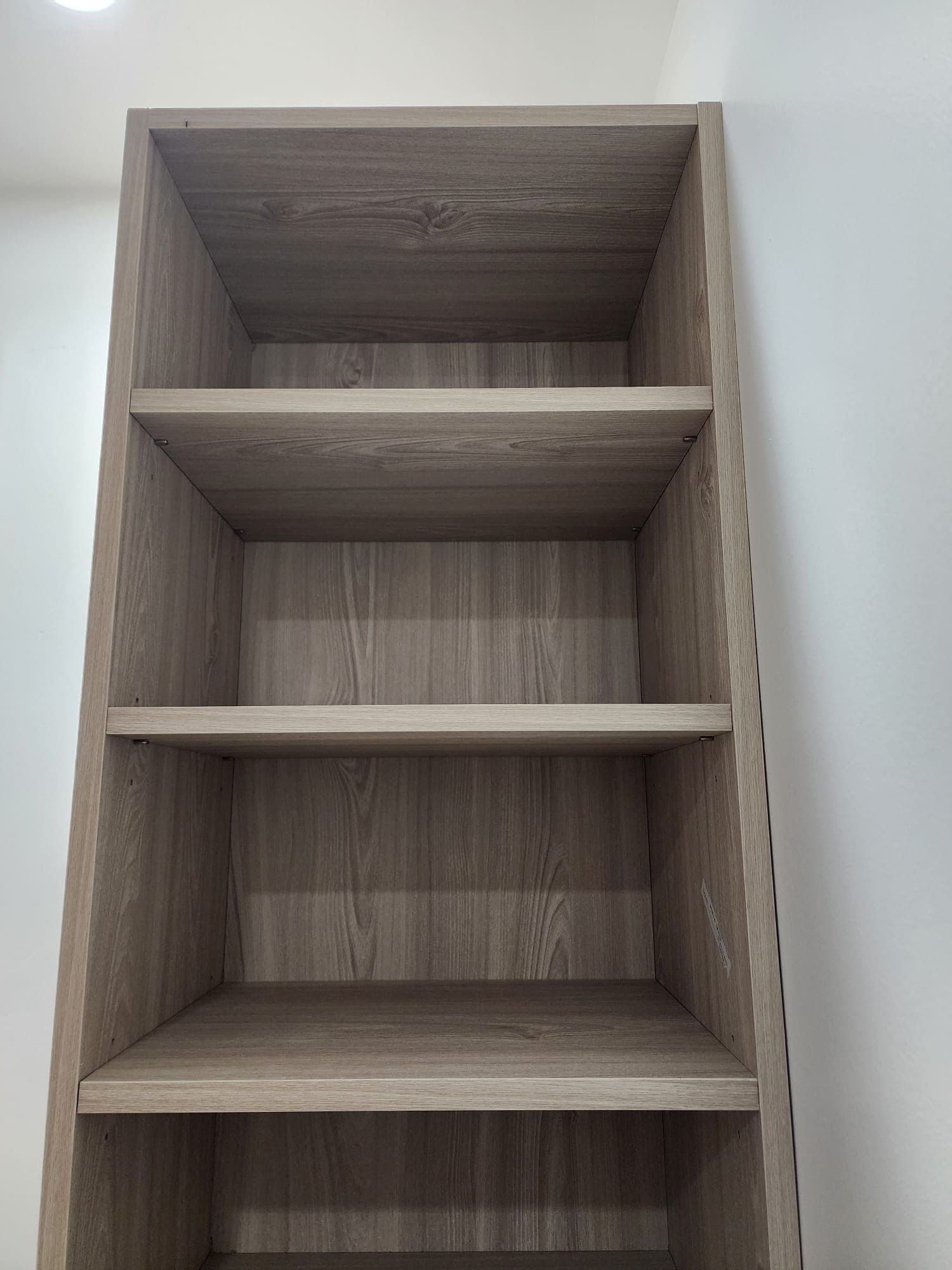 A wood walk in closet cabinets with lots of shelves 